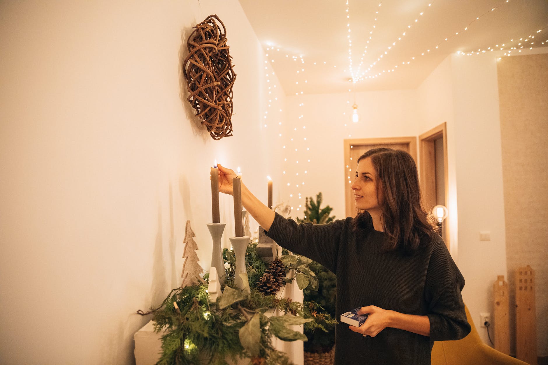 woman lighting christmas candle