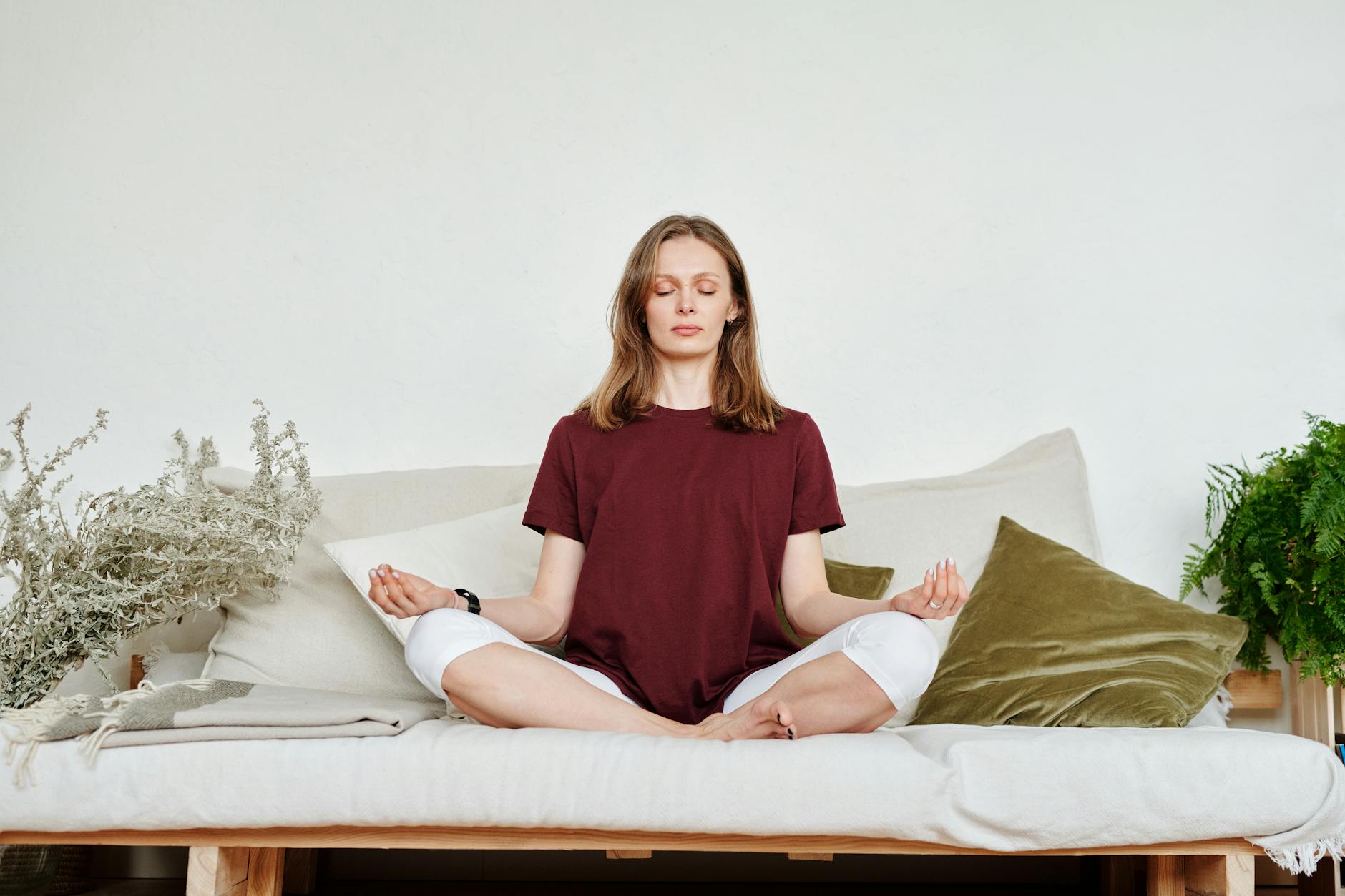 woman in red shirt sitting on couch meditating