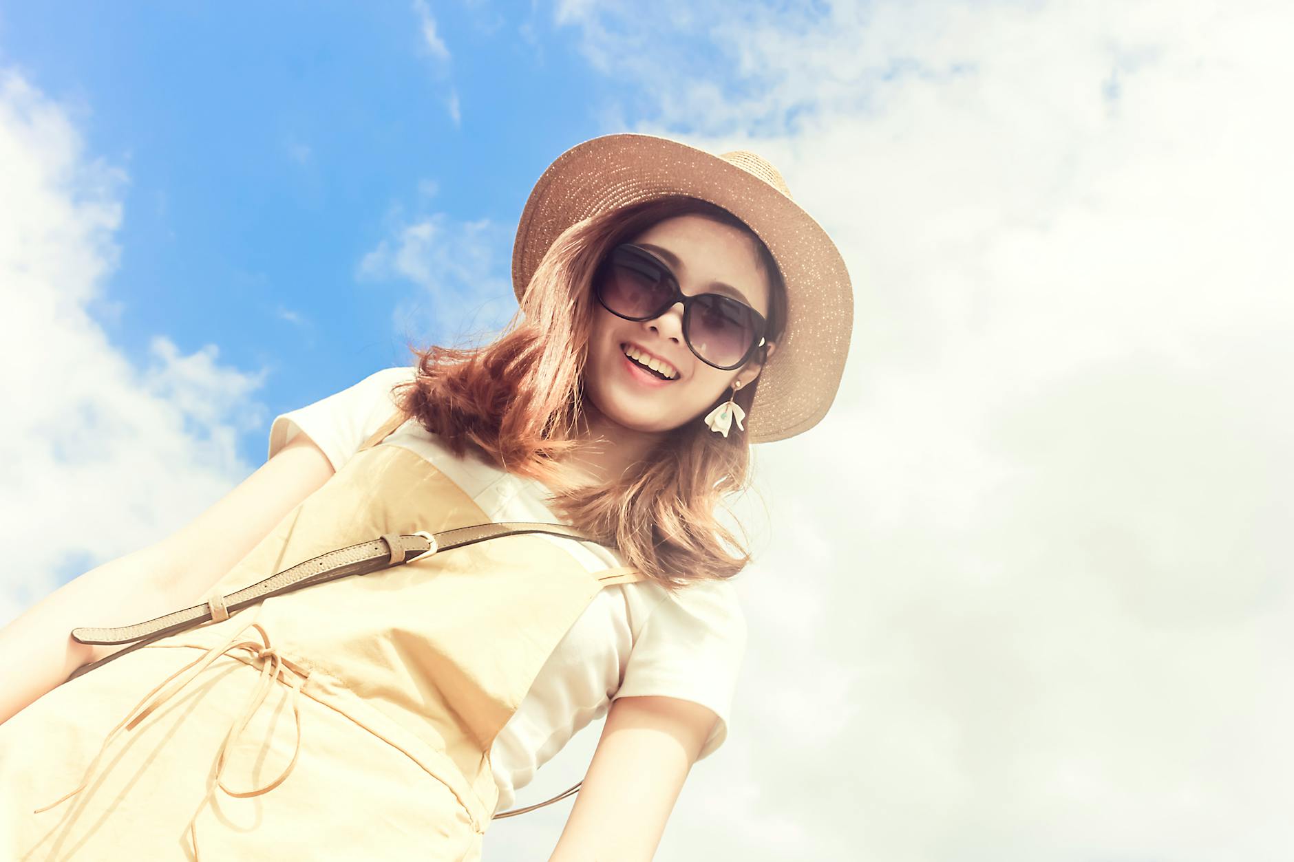 woman wearing dress smiling taking for picture under cloudy skies